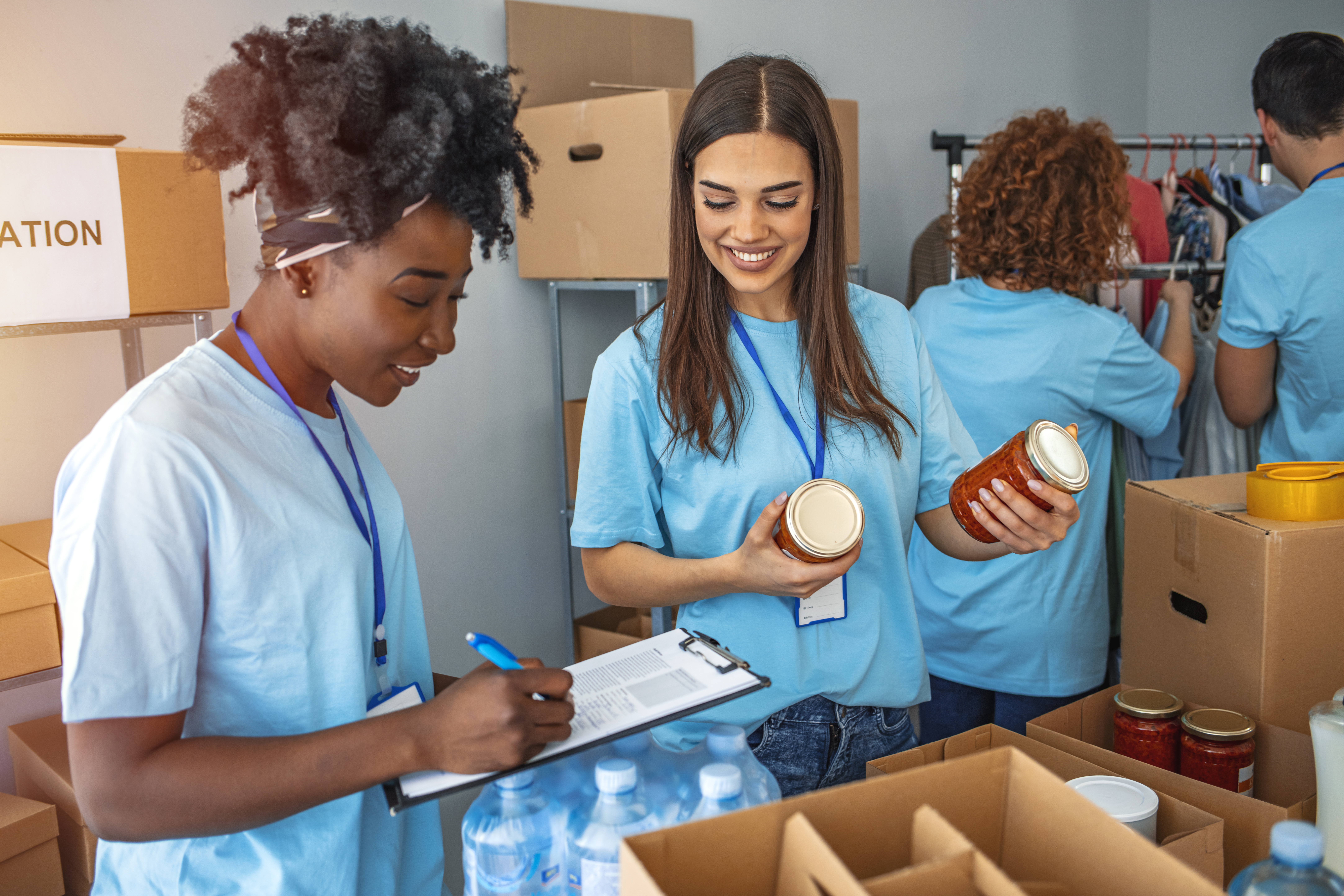 Two women box canned food.