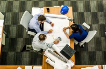 Overview of people working on a project on a table.