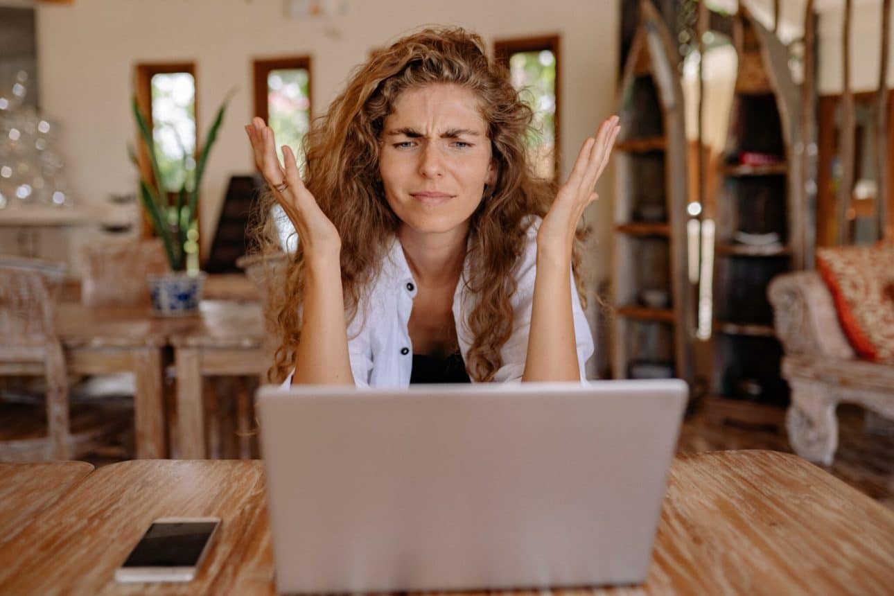 A confused women exclaiming at a computer.